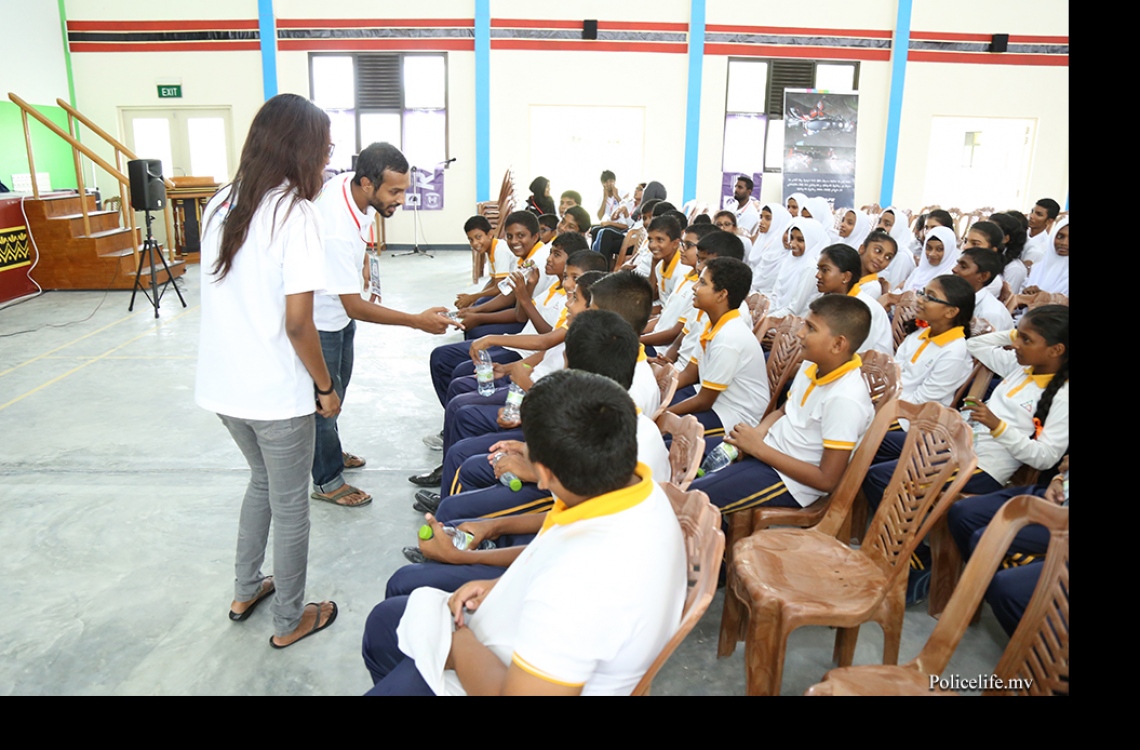 ލ. އަތޮޅު: މޭ 9، 2016: ފުލުހުންނާ އެލައިޑް އިންސިއުރެންސާ އެކުވެގެން ލ. އަތޮޅުގު ބައެއް ރަށްރަށުގައި ޓްރެފިކާ ގުޅޭގޮތުން އާންމުން ހޭލުންތެރިކުމަށް ބޭއްވި "ރައްކާ" ޕްރޮގްރާމުގައި ދަރިވަރުންނަށް ކިޔަވާދެނީ.-- ފޮޓޯ: ޕޮލިސް