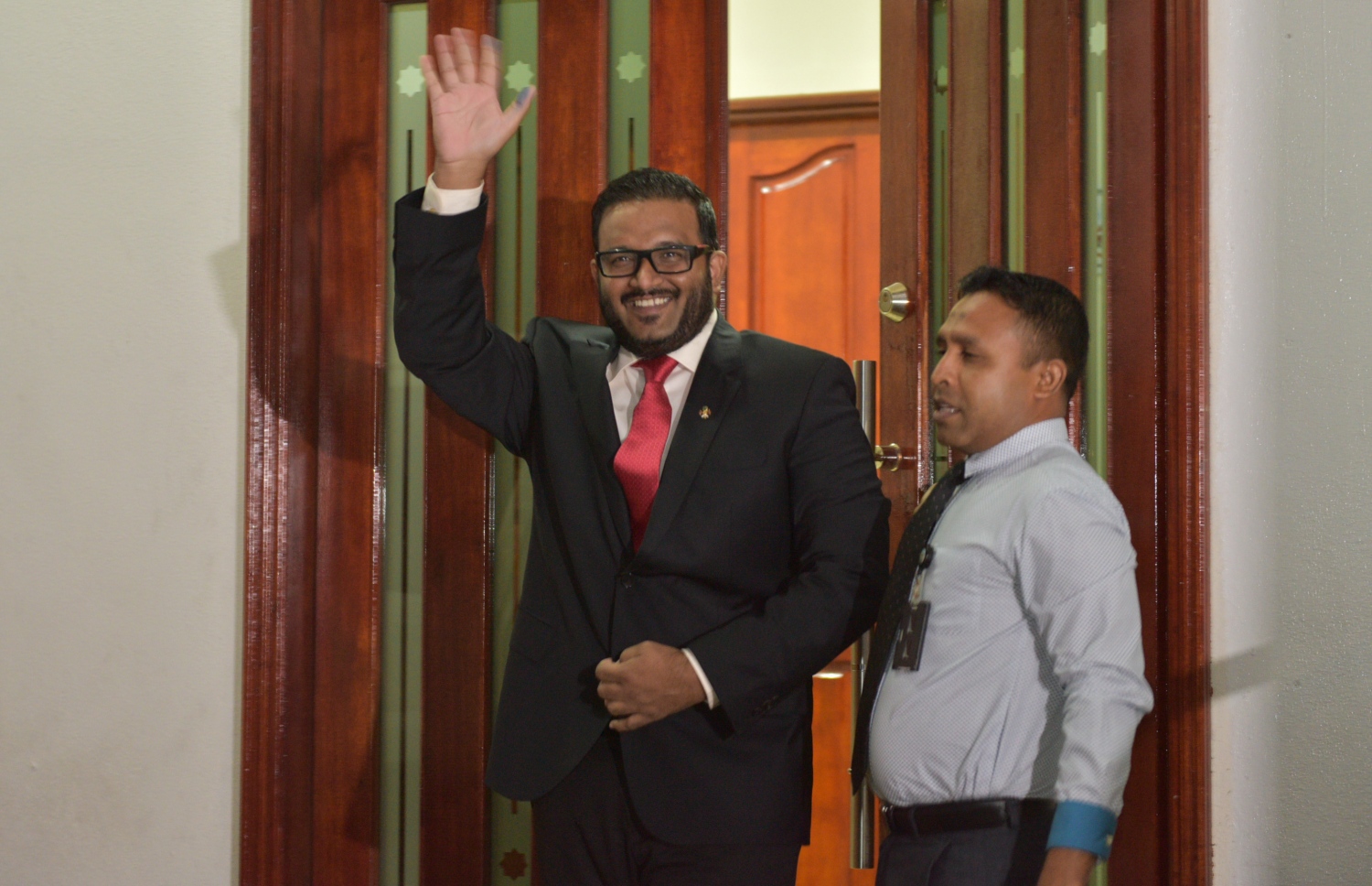 ކުރީގެ ނައިބު ރައީސް އަހްމަދު އަދީބަށް ހުކުމް ކުރުމަށް ފަހު ކޯޓުން ނެރުމާ އެކު، ކޯޓު ބޭރުގައި ތިބި މީހުންނަށް އަތުން އިޝާރާތްކޮށްލައްވަނީ. -- ފޮޓޯ: މުހައްމަދު ޝަރުހާން/މިހާރު