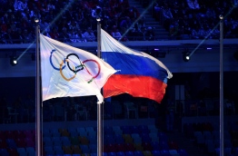 (FILES) This file photo taken on February 23, 2014 shows an Olympic Games flag and a Russian flag waving during the closing ceremony of the winter Olympics in Sotchi.

Russia operated a state-dictated doping system during the 2014 Sochi Winter Olympics and other events, an independent investigator said today in a report likely to lead to demands for Russia to be completely banned from the Rio Games. / AFP PHOTO / ANDREJ ISAKOVICANDREJ ISAKOVIC/AFP/Getty Images