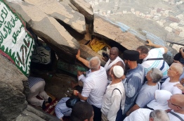 ހިރާ ފަރުބަދައިގެ ހޮހޮޅައިގެ ތެރޭގައި މީހަކު ނަމާދު ކުރާ އިރު، އެހެން މީހުންތައް އެ ހޮހޮޅައިން ޖާގައެއް ހޯދުމަށް ހޮހޮޅައިގެ ދޮރުމައްޗަށް ބޮނޑިވެފައި. --ފޮޓޯ އަހްމަދު އަބްދުﷲ ސައީދު/މިހާރު