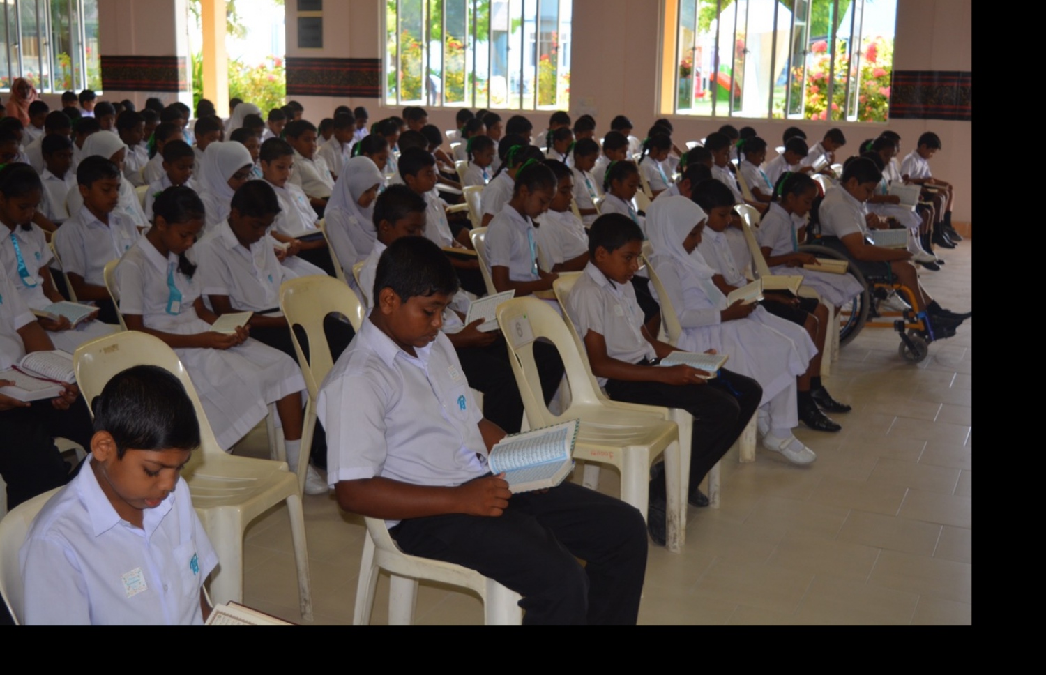 ނ. ވެލިދޫގައި ހުންނަ ތައުލީމީ މަރުކަޒުގެ ދަރިވަރުން ދަރިވަރުން އެސެމްބްލީގައި ގުރުއާން ކިޔަވަނީ-- ފޮޓޯ: ނ. އަތޮޅު ތައުލީމީ މަރުކަޒު