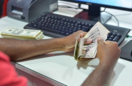A bank worker at BML counts USD 50 cash notes. Despite the introduction of Remittance Tax, Athif Shakoor states that the decrease in remittance revenue from 2016 to 2017 indicates that expatriates were by-passing the legal banking and money transfer networks. FILE PHOTO/MIHARRU