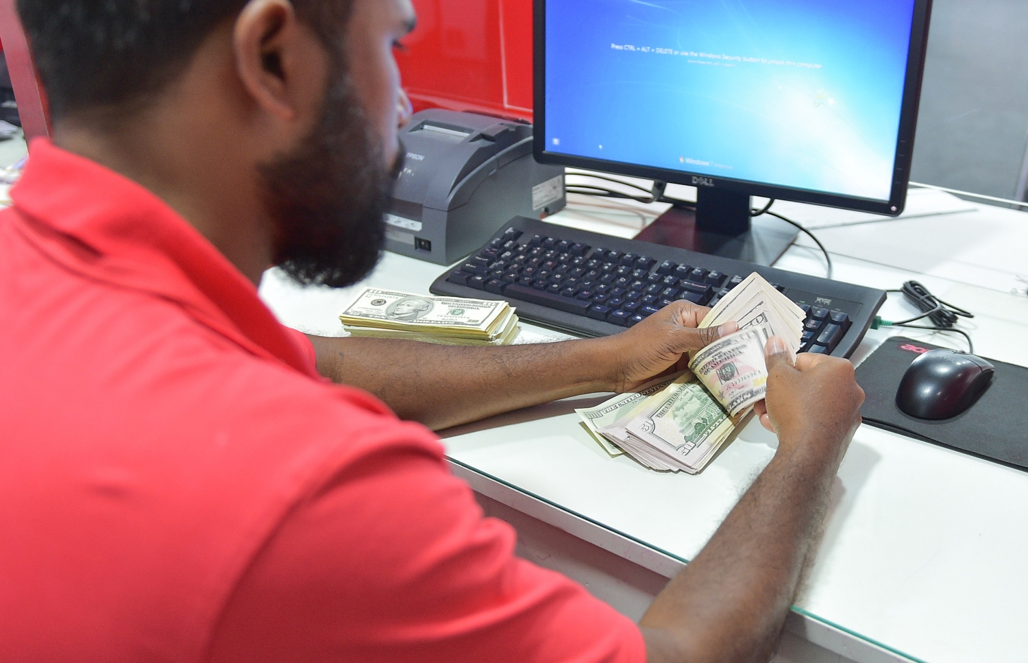 ބީއެމްއެލްގެ މުވައްޒަފަކު ޑޮލަރު ގުނަނީ: .---މިހާރު ފޮޓޯ