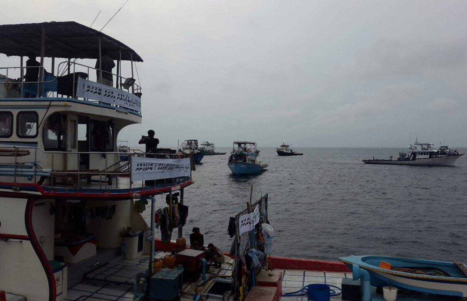 މަސްވެރިން ފެލިވަރު ބޭރުގައި ދޯނިތަކުގައި ތިބެގެން މުޒާހަރާ ކުރަނީ. -- ފޮޓޯ: ރާއްޖެޓީވީ