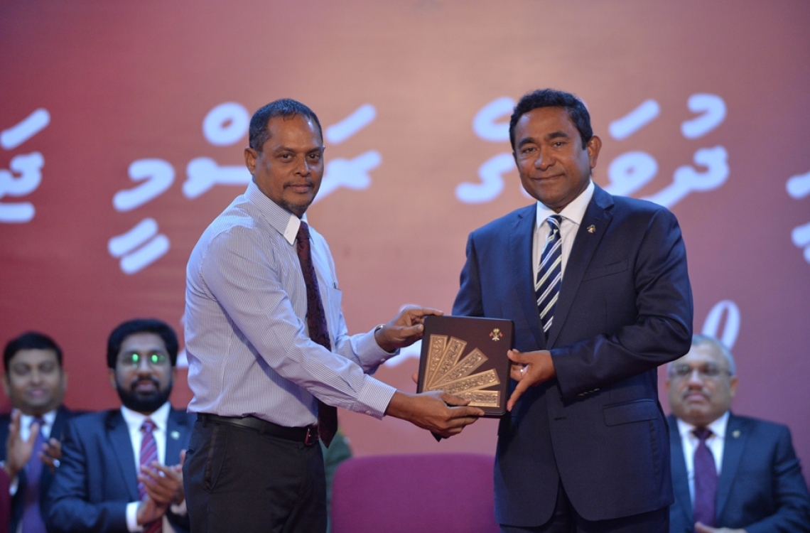 މާލެ: ނޮވެމްބަރު 10، 2016- ޖުމްހޫރީ ދުވަހުގެ މުނާސަބަތުގައި ބޭއްވި ރަސްމީ ޖަލްސާގައި، ނޫސްވެރިކަމުގެ ދާއިރާއިން ހިތްވަރު ދިނުމުގެ ގައުމީ އިނާމު ސަން އޮންލައިންގެ އެޑިޓަ އިން ޗީފް އަހުމަދު ޒާހިރު (ހިރިގާ) އަށް ރައީސް ޔާމީން ދެއްވަނީ: ހިރިގާ ޒާހިރު ވަނީ ނޫސްވެރިކަމުގައި 28 އަހަރު ހޭދަކުރަވާފައި.---ފޮޓޯ: ރައީސް އޮފީސް