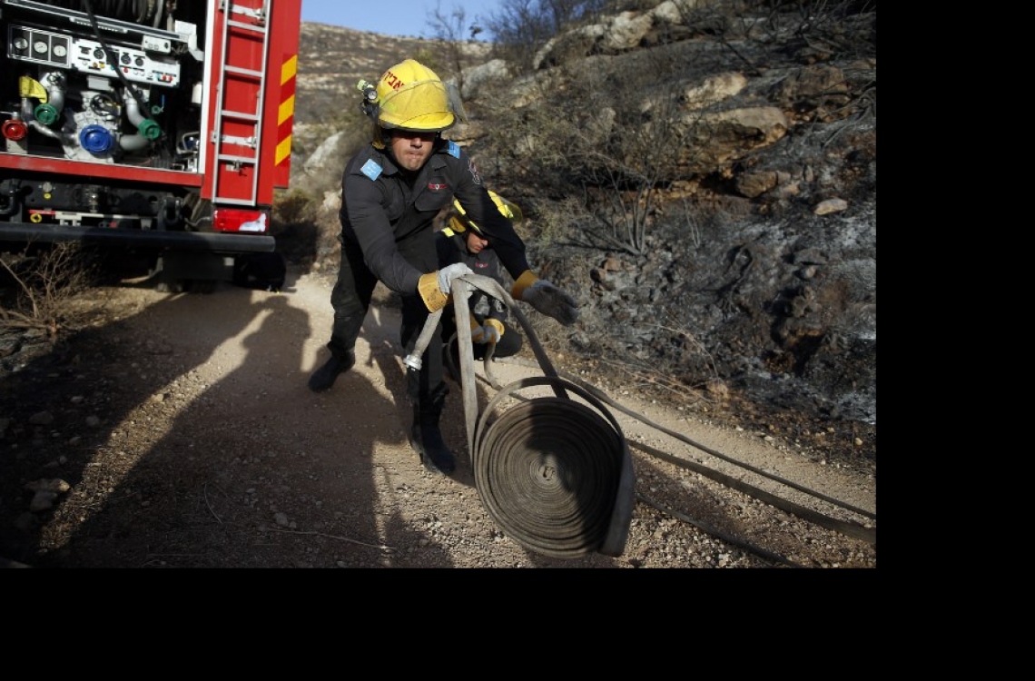 އިޒްރޭލުގައި ރޯވި އަލިފާން ނިއްވާލުމަށް އަލިފާން ނިއްވާ މީހަކު މަސައްކަތް ކުރަނީ. --ފޮޓޯ:އޭއެފްޕީ
