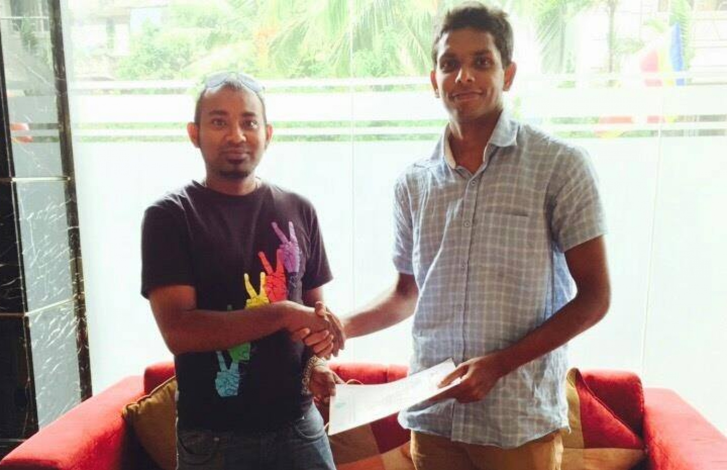 އީގަލްސްގެ ޖެނެރަލް ސެކްރެޓަރީ މުފާ (ވ-2) ސްރީ ލަންކާ ގޯލްކީޕަރު ސުޖަން ޕެރޭރާއާ އެކު އެއްބަސްވުމުގައި ސޮއިކުރުމަށް ފަހު ފޮޓޯއަކަށް ހުއްޓިގެން.