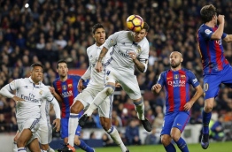 Real Madrid's defender Sergio Ramos (C) heads a ball to score the equalizer past Real Madrid's French defender Raphael Varane (3rdL) and Barcelona's Argentinian defender Javier Mascherano (R) during the Spanish league football match FC Barcelona vs Real Madrid CF at the Camp Nou stadium in Barcelona on December 3, 2016. / AFP PHOTO / PAU BARRENA