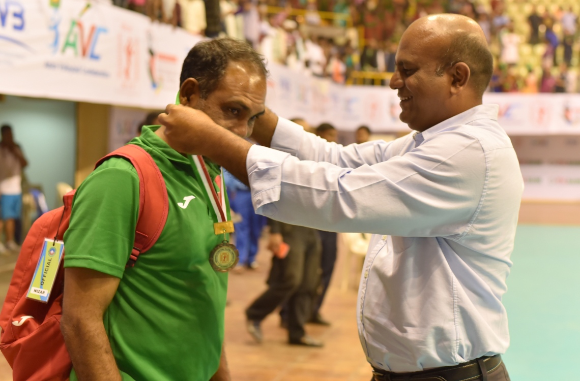 ބަންގްލަދޭޝް، ޑާކާ: ޑިސެމްބަރު 27، 2016: ވީއޭއެމްގެ ރައީސް ލަތީފް (ކ) ޓީމުގެ އެސިސްޓަންޓް ކޯޗު ނިޒާރު ކަރުގައި މެޑަލް އަޅުވަނީ.-- ފޮޓޯ: މިހާރު