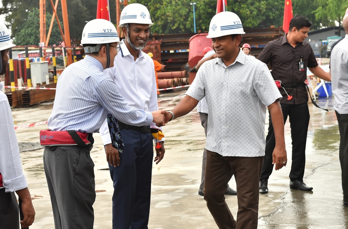 މާލެ: ޑިސެމްބަރު 28، 2016: ހުޅުލެ އާއި މާލެއާ ދެމެދު އަޅާ ބްރިޖުގެ މަސައްކަތް ކުރަމުން އަންނަ ސަރަހައްދަށް ރައީސް އަބްދުﷲ ޔާމީންގެ ދެކަނބަލުން ވަޑައިގަތުމުން، ޗައިނާގެ ސީސީސީސީ ކުންފުނީގެ އިސް ބޭފުޅުން އެކަނބަލުންނަށް މަރުހަބާ ކިޔުއްވަނީ.-- ފޮޓޯ: ރައީސް އޮފީސް