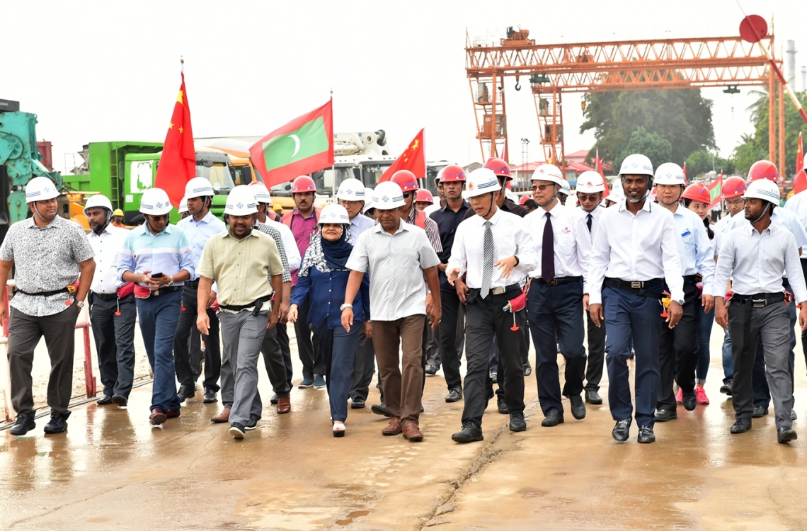 މާލެ: ޑިސެމްބަރު 28، 2016: ހުޅުލެ އާއި މާލެއާ ދެމެދު އަޅާ ބްރިޖުގެ މަސައްކަތް ކުރަމުން އަންނަ ސަރަހައްދަށް ރައީސް އަބްދުﷲ ޔާމީންގެ ދެކަނބަލުންނާއި ބައެއް ވަޒީރުންނާއި އަދި ޗައިނާގެ ސީސީސީސީ ކުންފުނީގެ އިސް ބޭފުޅުން ވަޑައިގެން ބައްލަވައި ލައްވަނީ.-- ފޮޓޯ: ރައީސް އޮފީސް