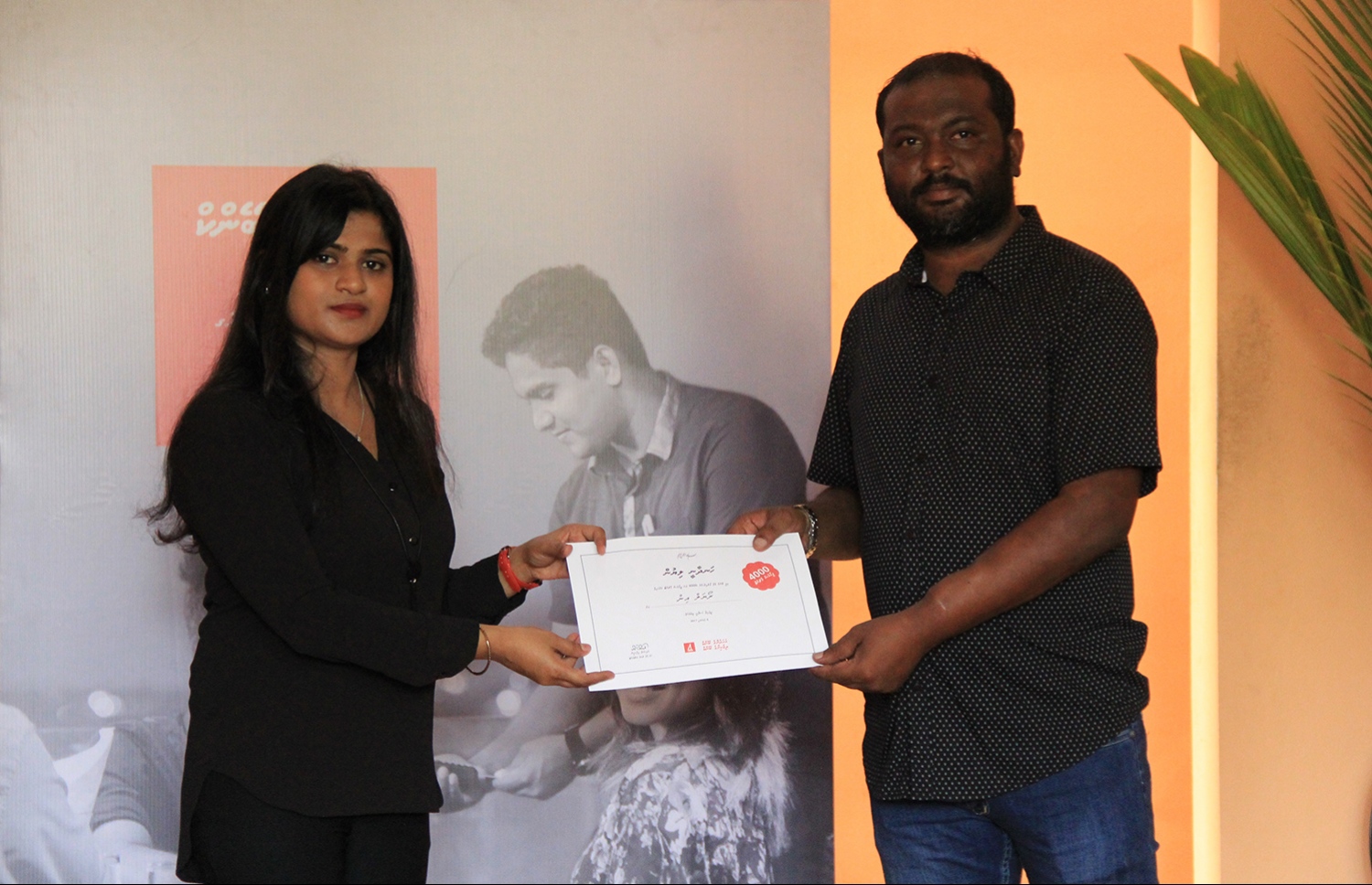 ބީއެމްއެލްގެ ކާޑު މެޝިން ބޭނުންކުރަން ފެށި 4،000 ވަނަ ތަން ކަމަށްވާ އއ. ރަސްދޫ ރޯޔަލް އިން ގެސްޓްހައުސްގެ އިސް ވެރިޔަކާ އިއްޔެ ހަނދާނީ ފިލައެއް ހަވާލުކުރަނީ.-- ފޮޓޯ: ބީއެމްއެލް