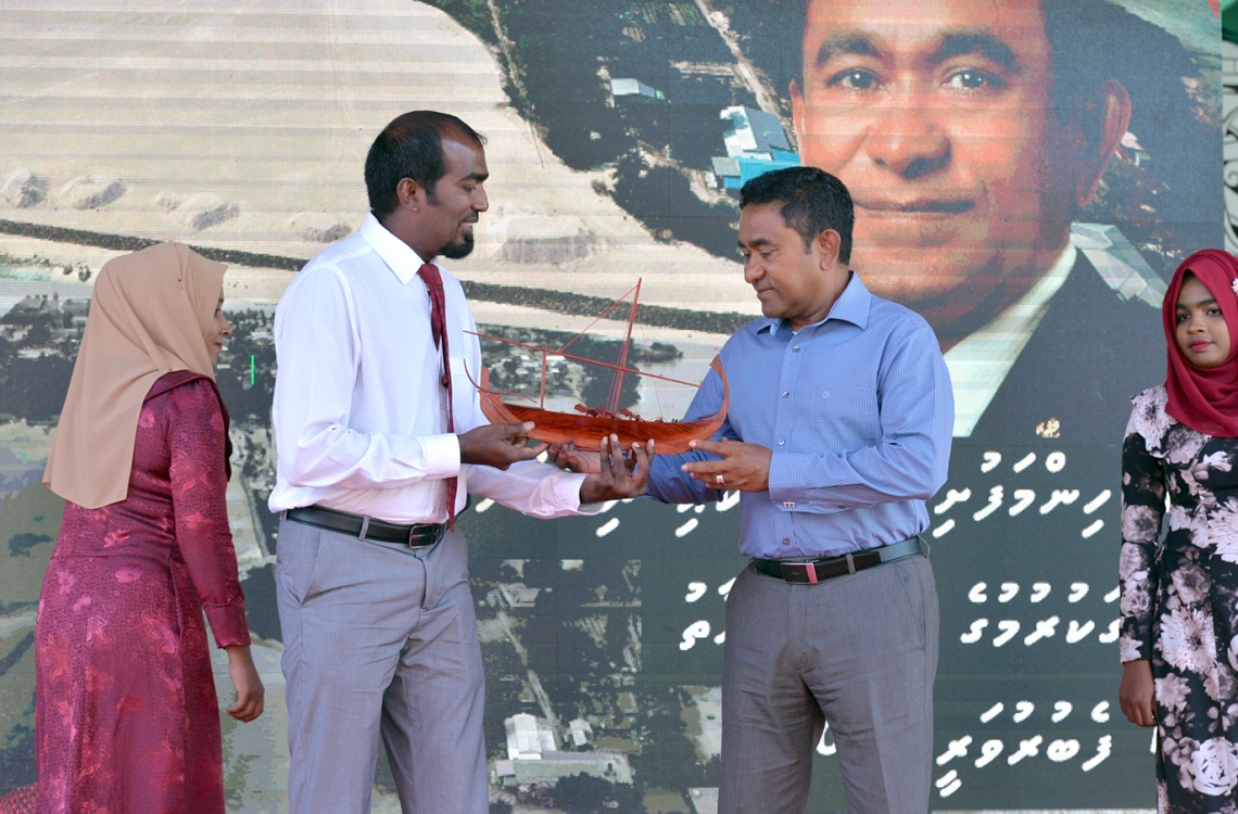 ކ. ހިންމަފުށި: ފެބްރުއަރީ 13، 2017- މި ރަށުގެ ބިން ހިއްކައި ނިންމުމުގެ ރަސްމިއްޔާތުގައި، ހިންމަފުށީ ކައުސިލްގެ ރައީސް ޝާން އިބްރާހީމް، ލަކުޑިން ހަދާފައިވާ ކުޑަ ދޯންޏެއް ރައީސް ޔާމީނަށް އަރުވަނީ.