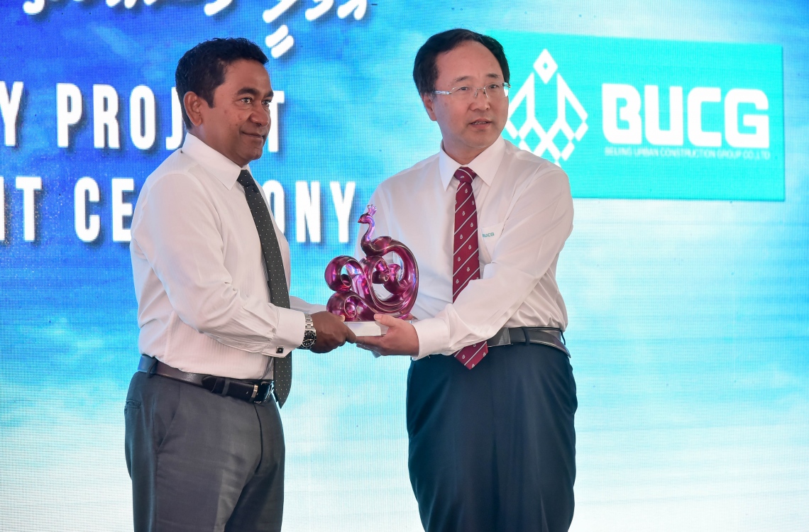 ހުޅުލެ: ފެބްރުއަރީ 27، 2017: ވެލާނާ އިންޓަނޭޝަނަލް އެއާޕޯޓްގެ އާ ރަންވޭގެ އަމަލީ މަސައްކަތް ފެށުމަށް ބޭއްވި ރަސްމިއްޔާތުގައި ބެއިޖިން އާބަން ކޮންސްޓްރަކްޝަން ގްރޫޕުގެ ޗެއާމަން (ކ)، ރައީސް ޔާމީނަށް ހަދިޔާއެއް ދެއްވަނީ.-- ފޮޓޯ: ނިޝާން އަލީ/ މިހާރު