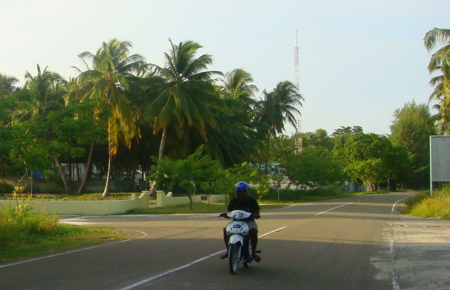 ހެލްމެޓް އަޅައިގެން މީހަކު ލިންކް ރޯޑްގައި ސައިކަލް ދުއްވާފައި ދަނީ.