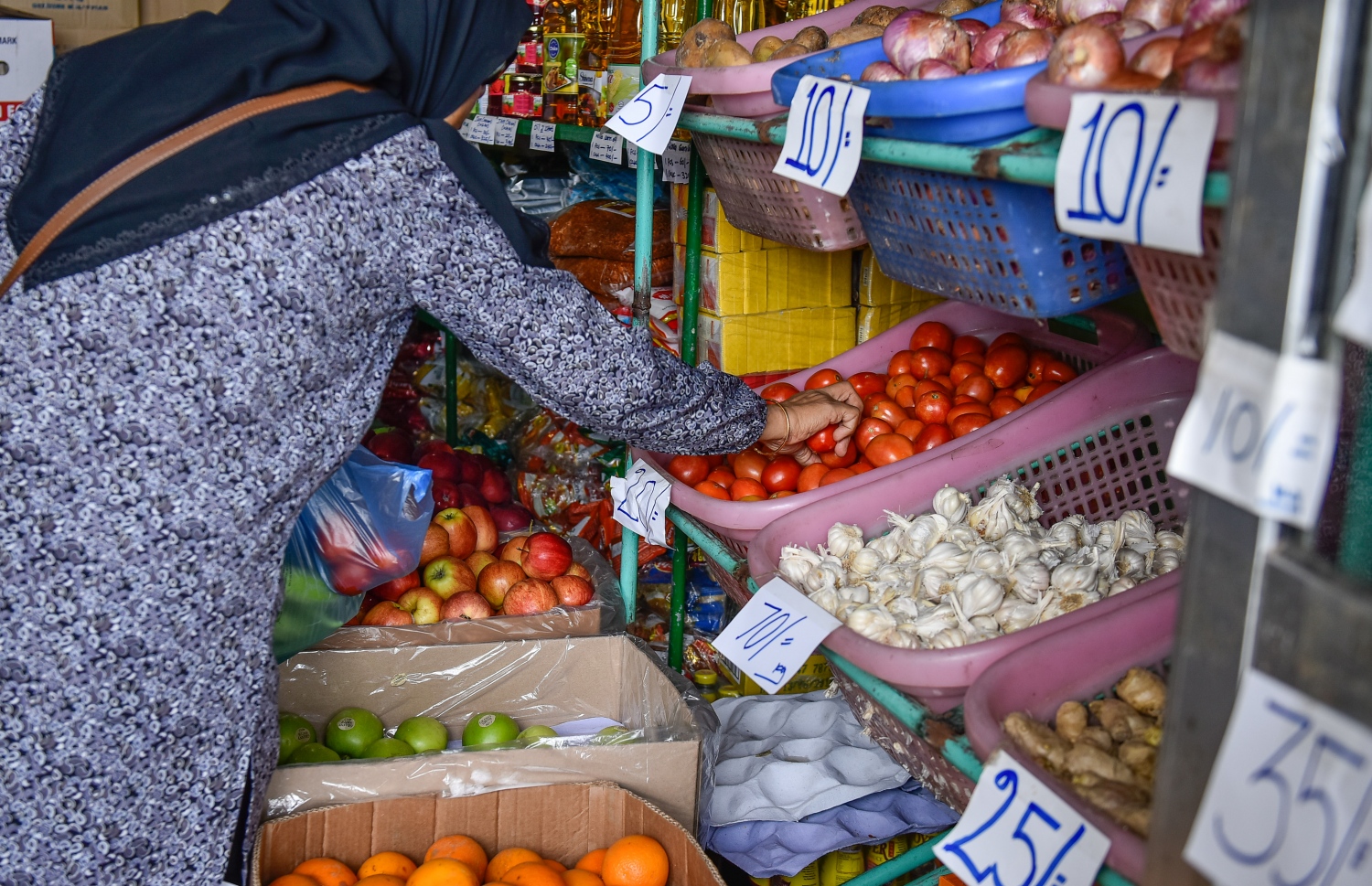 ބާޒާރުމަތީ ފިހާރައަކުން އަންހެނަކު ޓޮމާޓޯ ގަންނަނީ --ފޮޓޯ: ނިޝާން އަލީ /މިހާރު