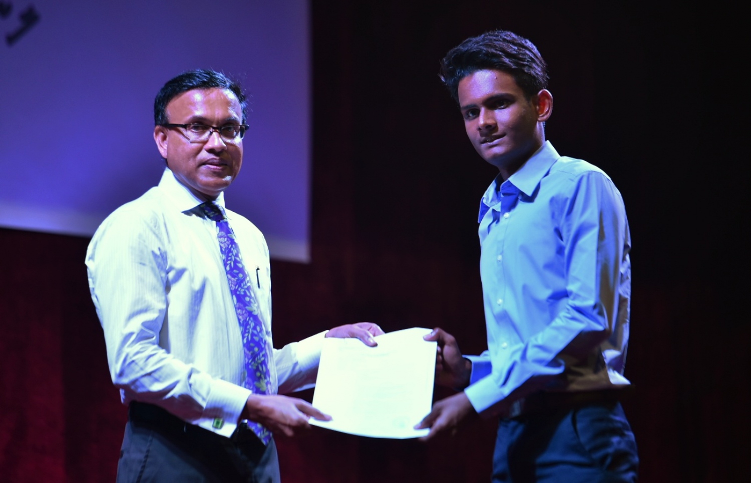 މަތީ ތައުލީމުގެ ލޯނު ލިބުނު ދަރިވަރަކަށް، ޑރ. ނަޒީރު ލިޔުން ހަވާލުކޮށް ދެއްވަނީ.---ފައިލް ފޮޓޯ: މިހާރު