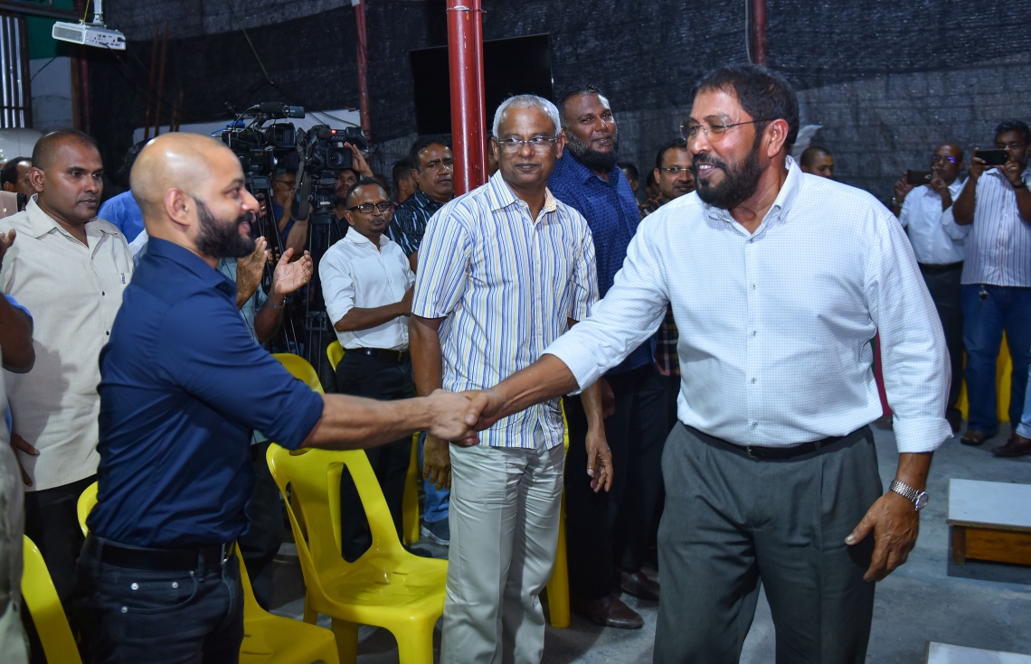 މާލެ، މޭ 17، 2017- އިދިކޮޅު ކޯލިޝަނުން އެމްޑީޕީގެ ހަރުގޭގައި ބޭއްވި ޖަލްސާގައި ޖުމްހޫރީ ޕާޓީގެ ލީޑަރު ގާސިމާއި ކުރީގެ ރައީސް މައުމޫންގެ ދަރިކަލުން ދިއްގަރު ދާއިރާގެ ފާރިސް ސަލާމް ކުރައްވަނީ.---މިހާރު ފޮޓޯ: ހުސެއިން ވަހީދު