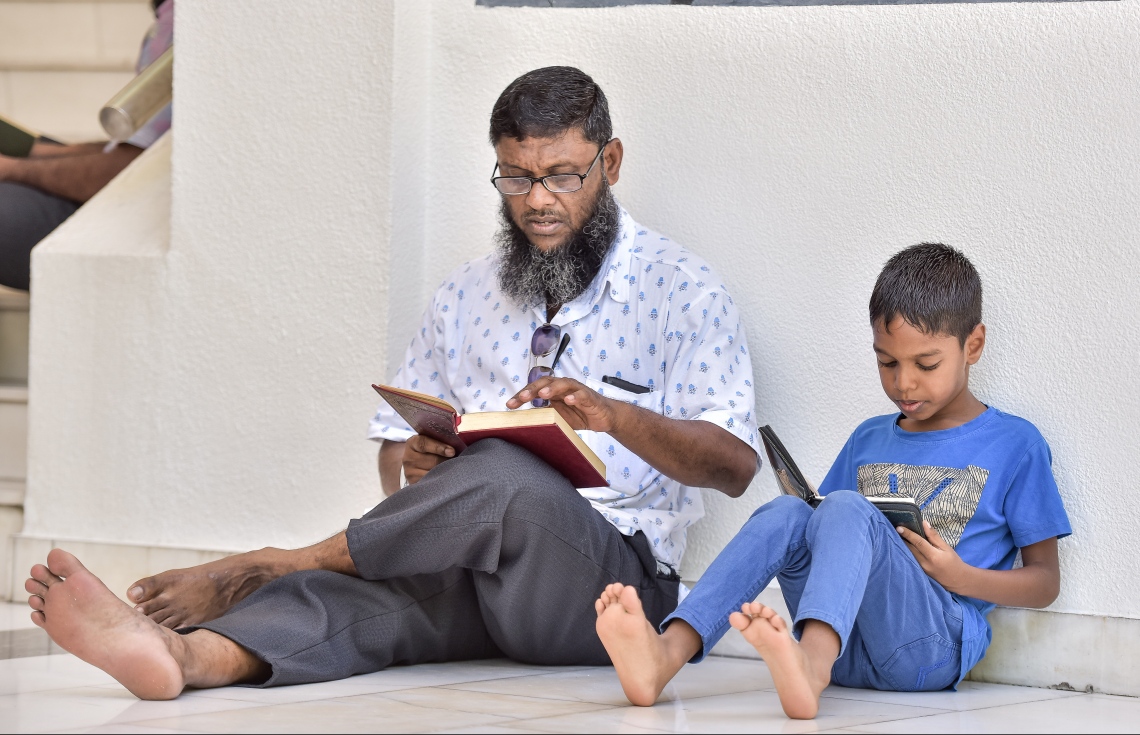 މާލެ: މޭ 27، 2017- މުލަރޯދަ ދުވަހު އިސްލާމީ މަރުކަޒުގައި ކުޑަކުއްޖަކާއި އޭނާގެ ބެލެނިވެރިޔާ ގުރުއާން ކިޔަވަނީ.---މިހާރު ފޮޓޯ: ނިޝާން އަލީ