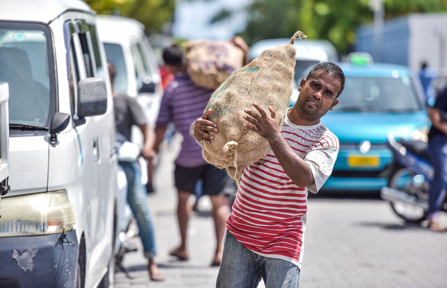 މާލޭގެ ބާޒާރު ސަރަހައްދުގައި މީހަކު އަލުވި ބަސްތާއެއް ހިފައިގެން ދަނީ: ރޯދަ މަހަށް ތަކެތީގެ އަގު އުފުލޭ މައްސަލަ ހައްލު ކުރުމަށް ވިޔަފާރިވެރިން ތެދުވަން ވެއްޖެ. -- މިހާރު ފޮޓޯ: ނިޝާން އަލީ