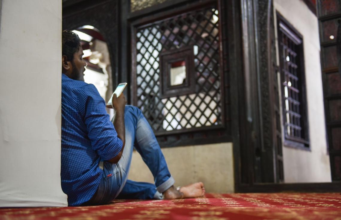 މާލެ: މޭ 27، 2017- ނަމާދު ކުރުމަށް ފަހު މީހަކު މޮބައިލް ފޯނެއް ބޭނުންކޮށްގެން މިސްކިތުގައި ގުރުއާން ކިޔަވަނީ.---މިހާރު ފޮޓޯ: ހުސެއިން ވަހީދު