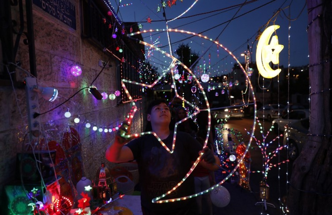 ފަލަސްތީނުގެ ކުއްޖަކު ޖެރޫސަމްގައި ރަމަޟާން ބޮކިތައް ހަމަޖައްސާލަނީ. --ފޮޓޯ:އޭއެފްޕީ