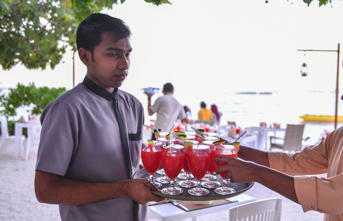 ހުޅުމާލޭގައި ހުންނަ އޯޝަން ގްރޭންޑް ގެސްޓް ހައުސްގައި ރޯދަ ވީއްލުމަށް ބީޗްގައި ކާބޯތަކެތި އަތުރައި ތައްޔާރުކުރުމުގައި ވެއިޓަރުން ހަރަކާތްތެރިވަނީ. -- ފޮޓޯ: ހުސެން ވަހީދު/މިހާރު