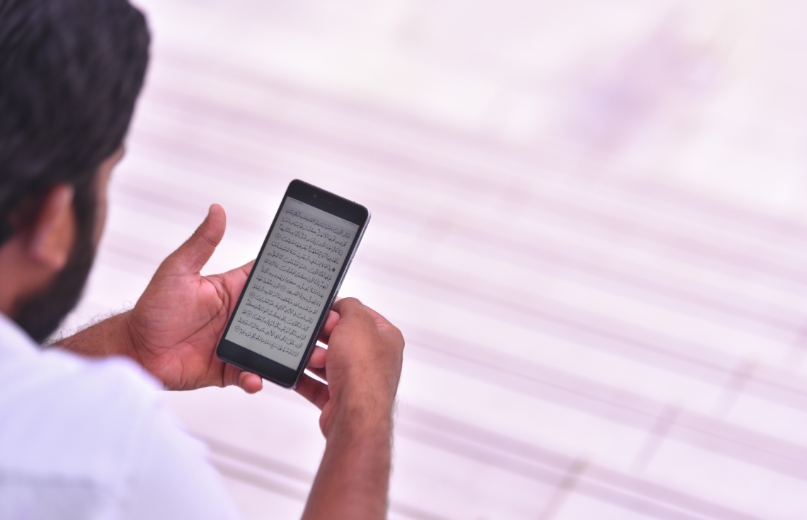 މާލެ: ޖޫން 17، 2017- މިސްކިތެއްގައި މީހަކު މޮބައިލް ފޯނުން ޤުރުއާން ކިޔަވަނީ: ޒަމާނަށް އައި ބަދަލާއެކު މޮބައިލް ފޯނުން ޤުރުއާން ކިޔަވާ މީހުން ގިނަ.---މިހާރު ފޮޓޯ: ހުސެއިން ވަހީދު