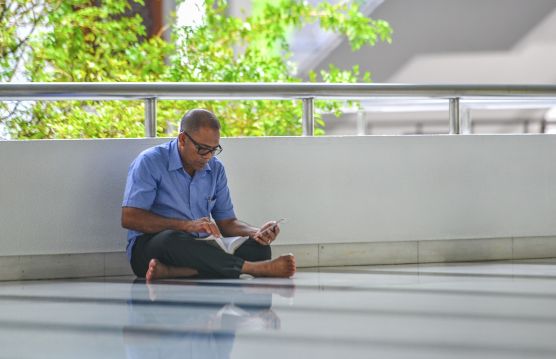 މާލެ: ޖޫން 17، 2017- މިސްކިތެއްގައި މީހަކު މޮބައިލް ފޯނުން އެއް އަތުން ހިފަހައްޓައިގެން އިނދެ، މުސްހަފުން ޤުރުއާން ކިޔަވަނީ: ޒަމާނަށް އައި ބަދަލާއެކު މޮބައިލް ފޯނުން ޤުރުއާން ކިޔަވާ މީހުން ގިނަ.---މިހާރު ފޮޓޯ: ހުސެއިން ވަހީދު