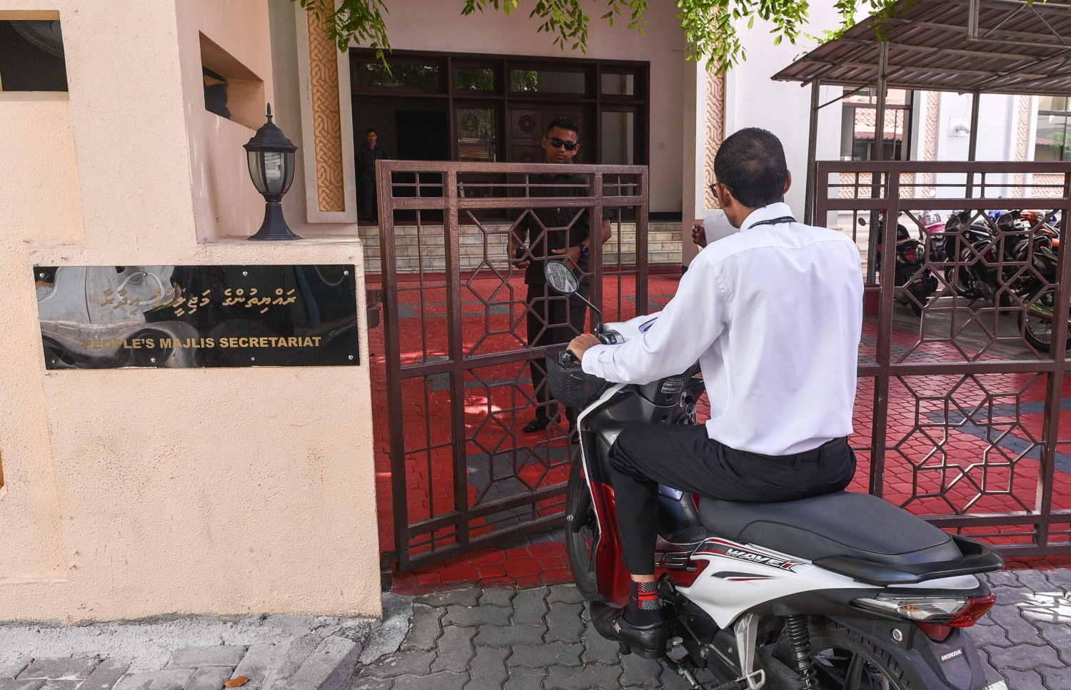 ރައްޔިތުންގެ މަޖިލިހުގެ އިދާރާގެ މުވައްޒަފަކު، އެތަނަށް ވަނުމަށްޓަަކައި ސިފައިންގެ މީހަކު މިއަދު ގޭޓް ހުޅުވައި ދެނީ.---މިހާރު ފޮޓޯ: ހުސެއިން ވަހީދު