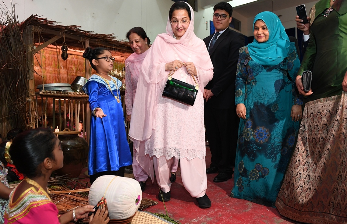 މާލެ: ޖުލައި 25، 2017- ރައީސް ޔާމީންގެ އަނބިކަނބަލުންނާއި ޕާކިސްތާނުގެ ބޮޑުވަޒީރުގެ އަނބިކަނބަލުން، ޖަމާލުއްދީން ސްކޫލަށް ކުރެއްވި ޒިޔާރަތުގައި ސްކޫލުގެ ދަރިވަރަކު އެތަނުގައި ކުރިއަށް ގެންދިޔަ އައިޓަމަކާ ބެހޭ މައުލޫމާތު ދެއްވަނީ.-- ފޮޓޯ: ރައީސް އޮފީސް