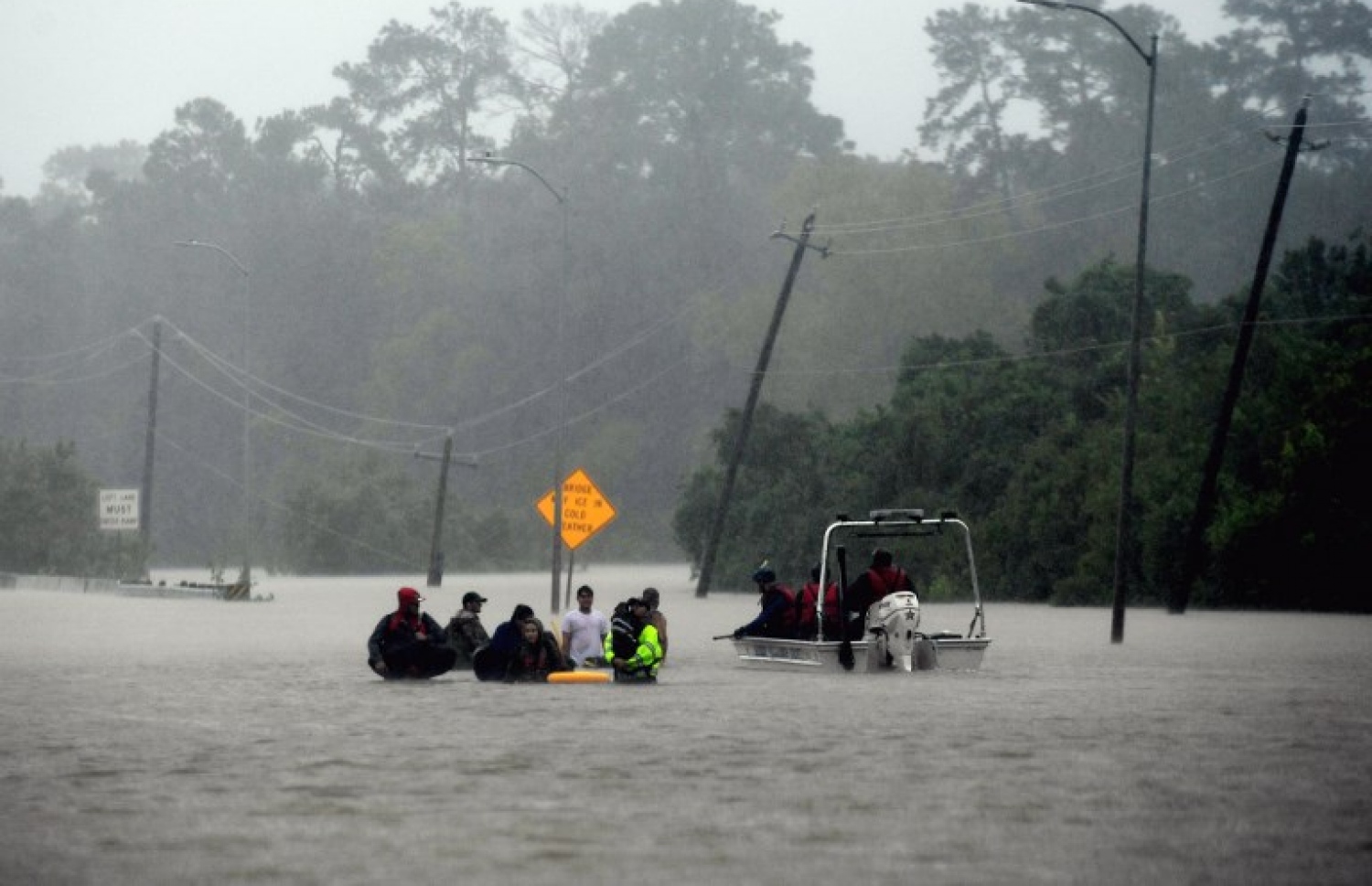 އެމެރިކާގެ ޓެކްސަސްގެ ހިއުސްޓަންގެ ފެންބޮޑުވެފައިވާ މަގަކުން އާއިލާއެއްގެ ބަޔަކު ދަނީ. --ފޮޓޯ:އޭއެފްޕީ