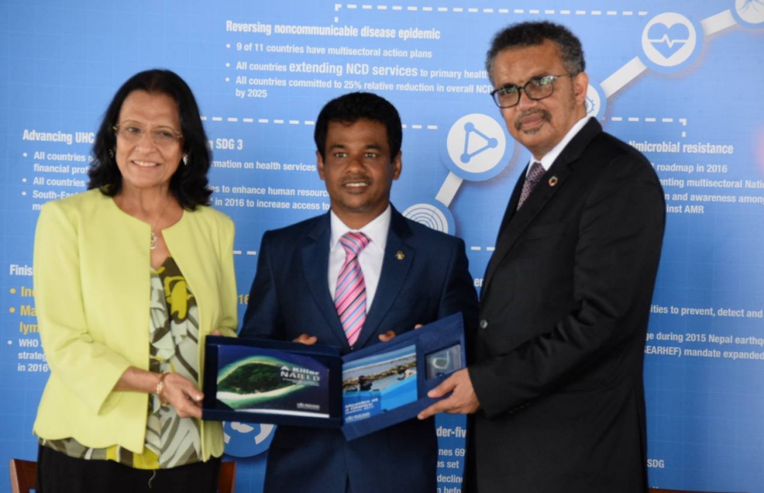 ހެލްތް މިނިސްޓަރު ނާޒިމަށް (މ)، ޑަބްލިއުއެޗްއޯގެ ޑިރެކްޓަ ޖެނެރަލް ޑރ. ޓެޑްރޮސް (ކ) އަދި އެ ޖަމިއްޔާއިން މި ސަރަހައްދަށް ހަމަޖައްސާފައިވާ ރީޖަނަލް ޑިރެކްޓަ ޑރ. ޕޫނަމް، ރާއްޖެއާ ބެހޭގޮތުން ތައްޔާރުކޮށްފައިވާ ފޮތެއް ދެއްވަނީ.-- ފޮޓޯ: ހެލްތް މިނިސްޓްރީ