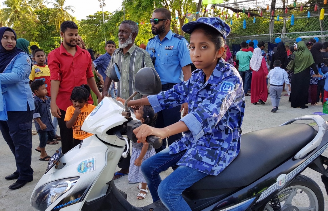 ވިލިމާލެ: ސެޕްޓެމްބަރު 9، 2017- ޕީސް ފައުންޑޭޝަނުން އިންތިޒާމުކޮށްގެން ވިލިމާލޭ ބޯޅަދަނޑުގައި ބޭއްވި އާއިލީ ހަވީރު "ޕެބްްލްސް"ގައި ހުރި ފުލުހުންގެ ސްޓޯލްގައި ކުޑަ ކުއްޖަކު ފުލުސް ޔުނީފޯމްގައި ފުލުހުންގެ ސައިކަލެއްގައި އިނދެ ފޮޓޯ ނަގަނީ. --- ފޮޓޯ: އަހުމަދު އަބްދުﷲ ސައީދު/ މިހާރު