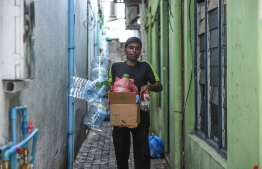 State-owned Waste Management Corporation Limited (WAMCO)'s staff taking out garbage from a home in capital Male City. PHOTO: HUSSAIN WAHEED/MIHAARU