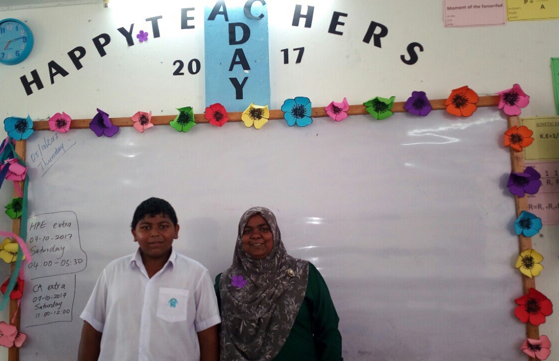 މާލެ: އޮކްޓޯބަރު 5، 2017: އއ. ތައުލީމީ މަރުކަޒުގައި ޓީޗަރުންގެ ދުވަސް ފާހަގަ ކުރުމުގެ ގޮތުން ބޭއްވި ހަރަކާތުގައި ޓީޗަރަކު ދަރިވަރަކާއެކު ފޮޓޯއަކަށް ހުއްޓިގެން.-- ފޮޓޯ: ހުސެން ވަހީދު/ މިހާރު