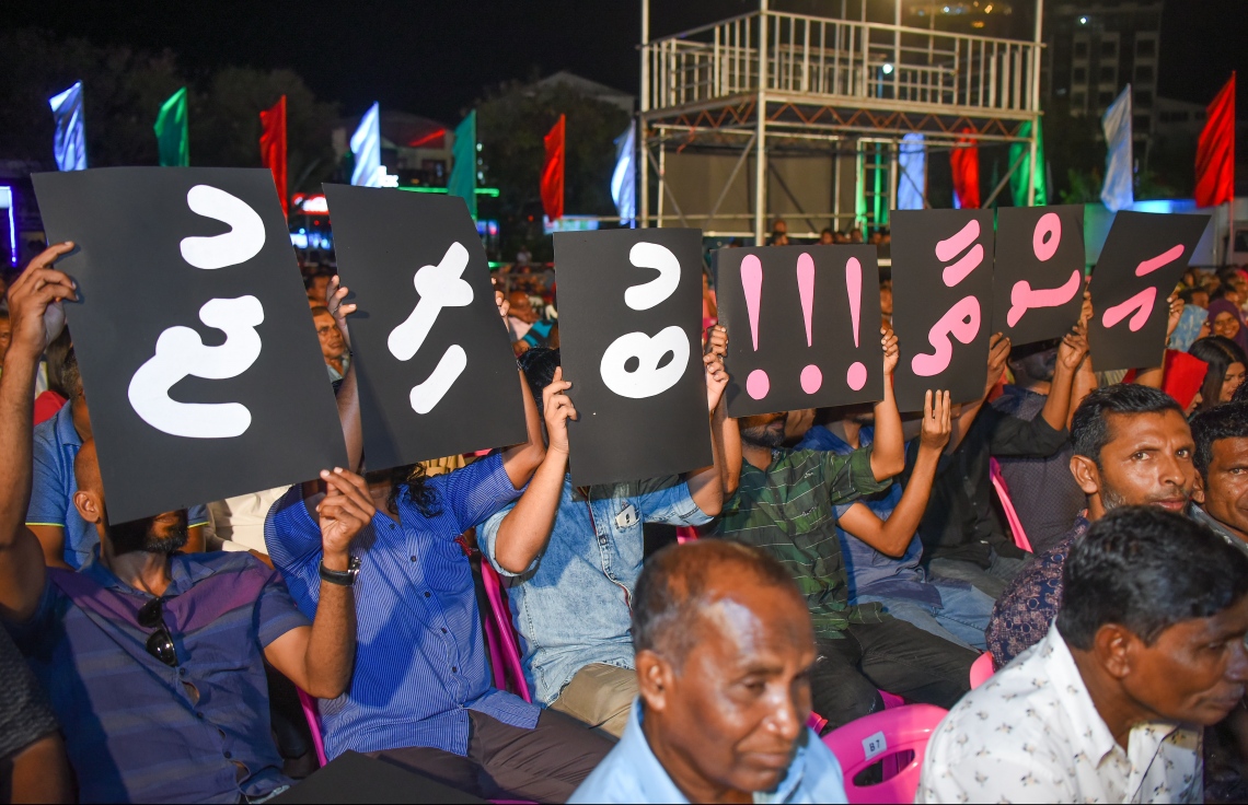 މާލެ: ނޮވެމްބަރު 9، 2017- "އަސްތާ" ގެ ނަމުގައި ޕީޕީއެމުން ބޭއްވި ޖަލްސާގައި، ރައީސް ޔާމީންގެ ތަރައްގީގެ އެންމެ މުހިންމު އެއް ތަން ކަމަށް ކުރިމަގުގައި ފެންނާނީ މާލެ-ހުޅުލެ ބްރިޖުކަން އަންގައިދޭ ލިޔުމެއް ދައްކާލަނީ.---ފޮޓޯ: ނިޝާން އަލީ/މިހާރު