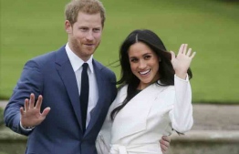 Britain's Prince Harry and his fiancée US actress Meghan Markle pose for a photograph in the Sunken Garden at Kensington Palace in west London on November 27, 2017, following the announcement of their engagement.
Britain's Prince Harry will marry his US actress girlfriend Meghan Markle early next year after the couple became engaged earlier this month, Clarence House announced on Monday. / AFP PHOTO / Daniel LEAL-OLIVAS