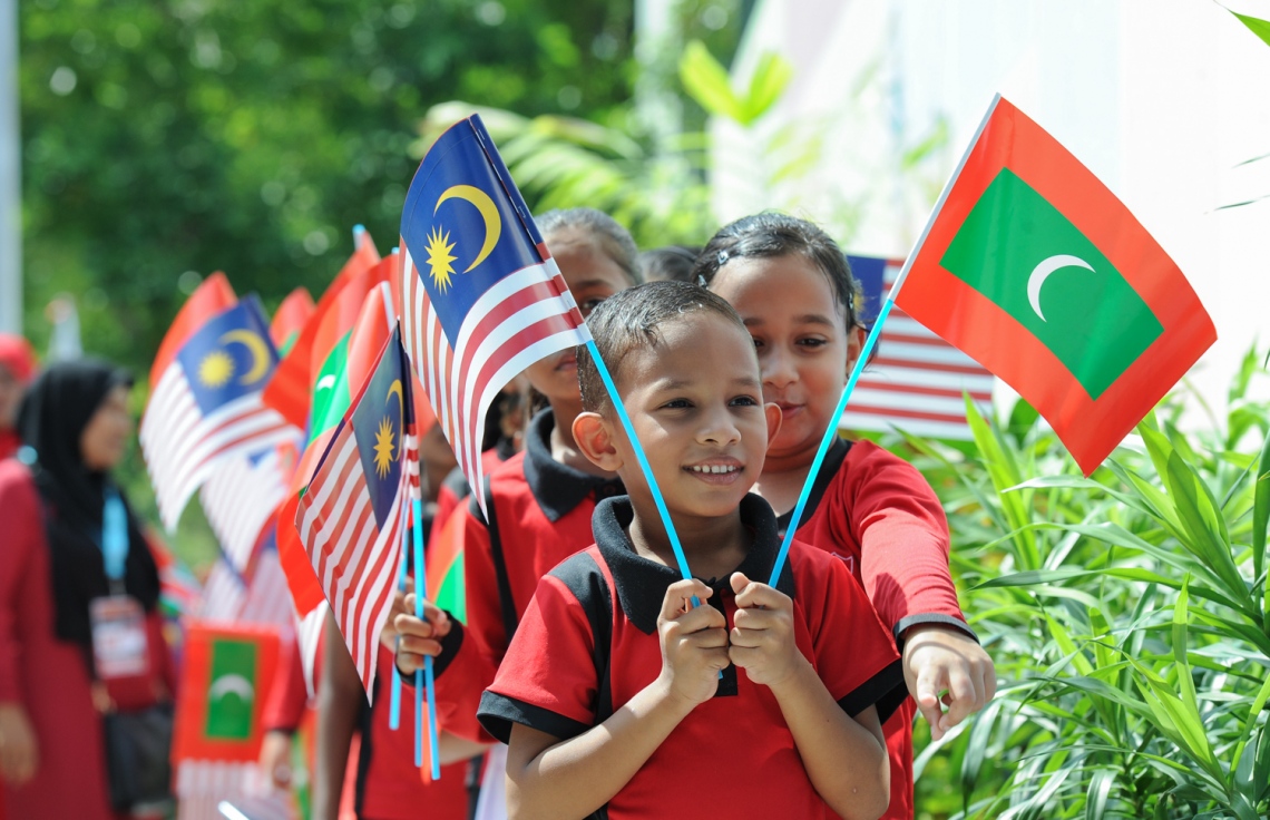 ހުޅުމާލެ: ޑިސެމްބަރު 20، 2017- މެލޭޝިއާގެ ބޮޑުވަޒީރު ނަޖީބު ރައްޒާގުގެ އަނބިކަނބަލުން ޕަޑުކާ ސެރީ ރޮސްމާހް މަންސޫރު، ހުޅުމާލޭގައި ހުންނަ ކުޑަކުދިން ބަލަހައްޓާ މަރުކަޒު، ފިޔަވައްޗަށް ޒިޔާރަތް ކުރައްވާތީ، ރާއްޖެ އާއި މެލޭޝިއާގެ ދިދަ ހިފައިގެން އެކަމަނާއަށް މަރުހަބާ ދެންނެވުމަށް އެތުރިގެން ތިބި ކުދިންތަކެއް..---ފޮޓޯ: ރައީސް އޮފީސް