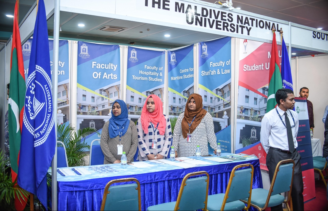 މާލެ:ޑިސެމްބަރު 21، 2017- މަތީ ތައުލީމަށް ކިޔެވުމަށް ސަރުކާރުން ދޭ 2050 ސްކޮލަޝިޕަށް މިއަދު ހުޅުވާލުމާ ގުޅިގެން، އެ ފުރުސަތަށް ހާއްސަކޮށްގެން ފެށި ފެއާގައި ހުރި މޯލްޑިވްސް ނޭޝަނަލް ޔުނިވަސިޓީގެ ސްޓޯލްގައި އެތަނުގެ ބައެއް މުވައްޒަފުން ހުއްޓިގެން: ރާއްޖޭގެ ދެ ޔުނިވާސިޓީ އާއި ކޮލެޖުތަކުން ހިންގާ ކޯސްތަކާ ބެހޭ މައުލޫމާތު ލިބޭ ފެއާ މިރޭ 10 ޖަހަންދެން ދަރުބާރުގޭގައި އޮންނާނެ.---ފޮޓޯ: ނިޝާން އަލީ/މިހާރު