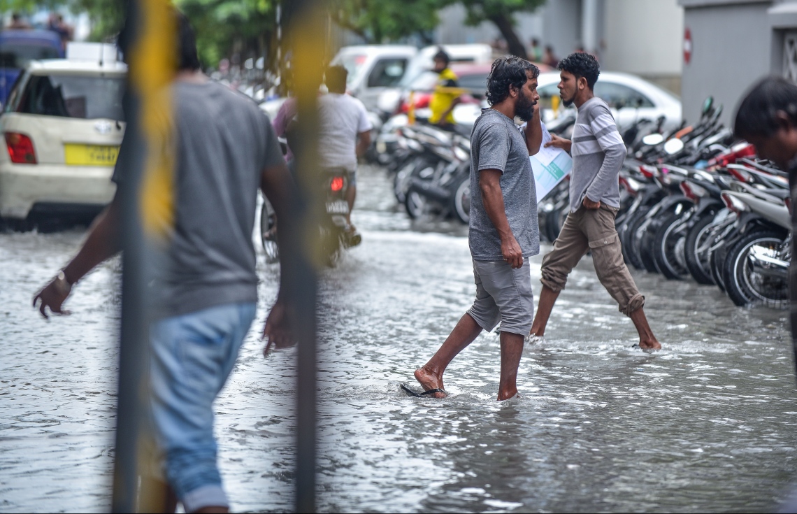މާލެ: ޖެނުއަރީ 3، 2018- ރޭ ފަތިހު މާލެއަށް ކުރި ވިއްސާރާގައި ފެންބޮޑުވެފައިވާ މަގެއްގައި ބަޔަކު ހިނގާފައި ދަނީ: ރޭ ފަތިހުން ފެށިގެން ހެނދުނު އަށެއް ޖެހުމާ ހަމައަށް މެދުނުކެނޑި ކުރި ވިއްސާރާގައި މާލޭގެ ބައެއް މަގުތަކުގައި ފެންބޮޑުވެ، އާންމުންނަށް ދަތިތައް ކުރިމަތިވި.---ފޮޓޯ: ނިޝާން އަލީ/މިހާރު