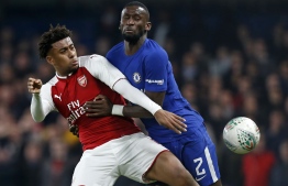 Arsenal's Nigerian striker Alex Iwobi (L) vies with Chelsea's German defender Antonio Rudiger during the English League Cup semi-final first leg football match between Chelsea and Arsenal at Stamford Bridge in London on January 10, 2018. / AFP PHOTO / Ian KINGTON / RESTRICTED TO EDITORIAL USE. No use with unauthorized audio, video, data, fixture lists, club/league logos or 'live' services. Online in-match use limited to 75 images, no video emulation. No use in betting, games or single club/league/player publications.  / 