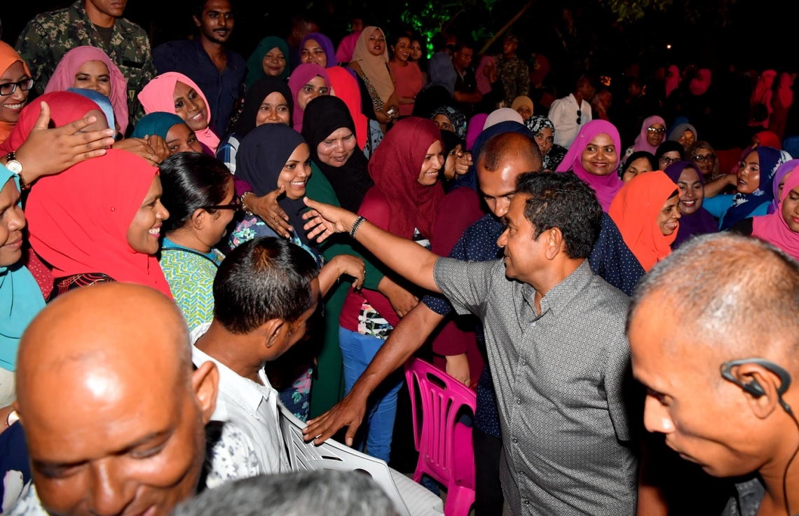 މާލެ: ފެބްރުއަރީ 7، 2018- ރައީސް ޔާމީނަށް އޮތް ތާއީދު ހާމަކުރުމަށް، ޕީޕީއެމްގެ އަންހެނުންތަކެއް އިސް ނަގައިގެން ބޭއްވި ޖަލްސާގައި ބައިވެރިވި މީހުންނަށް އެމަނިކުފާނު ސަލާމް ކުރައްވަނީ: "ގައުމަށްޓަކައި އަންހެނުން" ގެ ނަމުގައި ބޭއްވި ޖަލްސާއަށް ބޮޑު ތަރުހީބެއް ލިބުނު.---ފޮޓޯ: ރައީސް އޮފީސް
