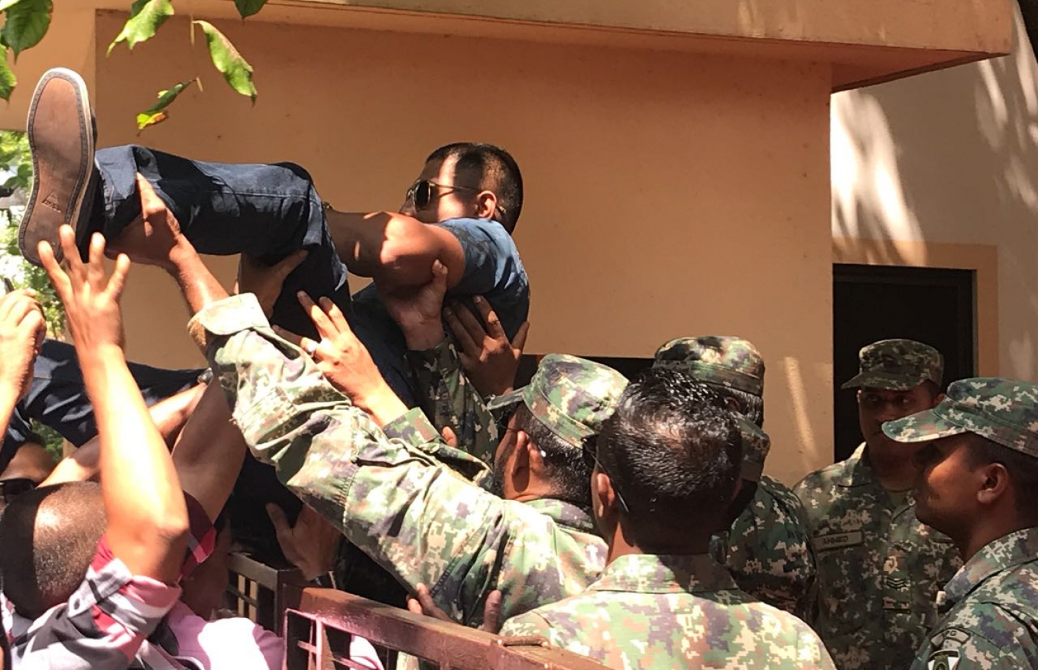 މަޖިލީހުގެ އިދާރާގެ ގޭޓު މަތިން ފުންމާލައިގެން އެތަނުގެ ތެރެއަށް ވަދެވަޑައިގެންނެވި މަހްލޫފް އުފުލާލައިގެން ސިފައިން ނެރެނީ: މަޖިލިސް ހިސޯރުކުރިކަމުގެ ތުހުމަތު ސިފައިންނަށް އޮވޭ --ފޮޓޯ: މިހާރު