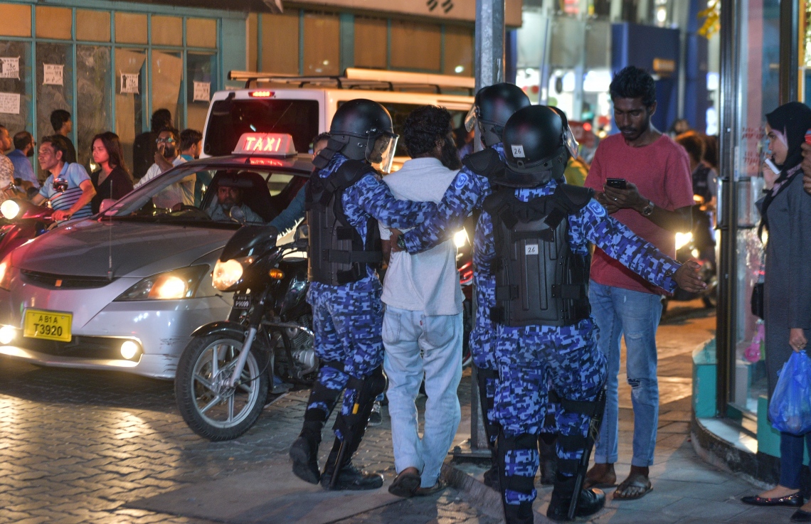 މާލެ: ފެބްރުއަރީ 16، 2018- އިދިކޮޅު ފަރާތްތަކުން މިރޭ މާލޭގައި ބޭއްވި އެއްވުން މަޖީދީ މަގާއި ޗާންދަނީ މަގު ގުޅުނު ސަރަހައްދުން ރޫޅާލައި، އެއްވުމުގެ ބައިވެރިއަކު ފުލުހުން ހައްޔަރުކުރަނީ.---ފޮޓޯ: ހުސެއިން ވަހީދު/މިހާރު