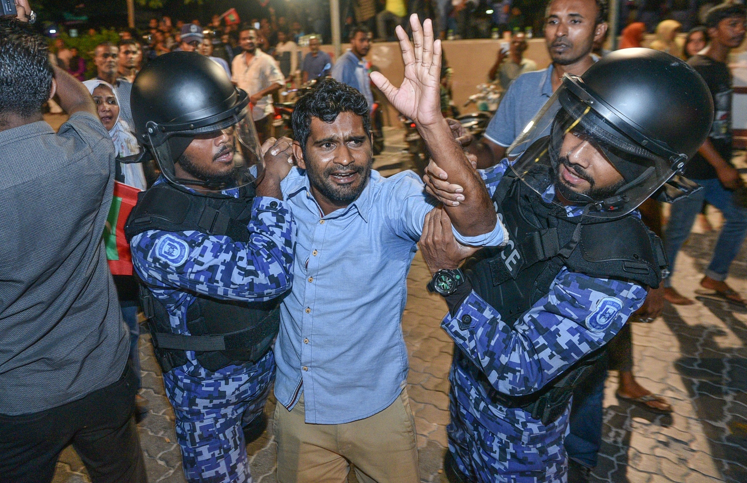 ރޭގެ އެއްވުމުގައި ބައިވެރިވި މީހަކު ފުލުހުންގެ ބެލުމުގެ ދަށަށް ގެންދަނީ.---ފޮޓޯ: ނިޝާން އަލީ/މިހާރު