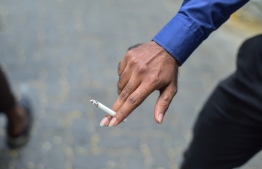 A man holding a cigarette. PHOTO: HUSSAIN WAHEED / MIHAARU