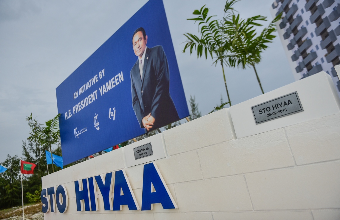 ހުޅުމާލެ: ފެބްރުއަރީ 26، 2018- އެސްޓީއޯ އިން ހުޅުމާލޭގައި ހަދާ 15 ބުރީގެ ރެޒިޑެންޝަލް ދެ ޓަވަރުގެ ބިންގާ މިއަދު އަޅާފައިވާއިރު އެތަނުގެ ކައިރީގައި ރައީސް ޔާމީންގެ ފޮޓޯފުޅެއް ހަރުކޮށްފައި: މިއީ ސީދާ އެމަނިކުފާނުގެ އިސް ނެންގެވުމެއް.---ފޮޓޯ: ހުސެއިން ވަހީދު/މިހާރު