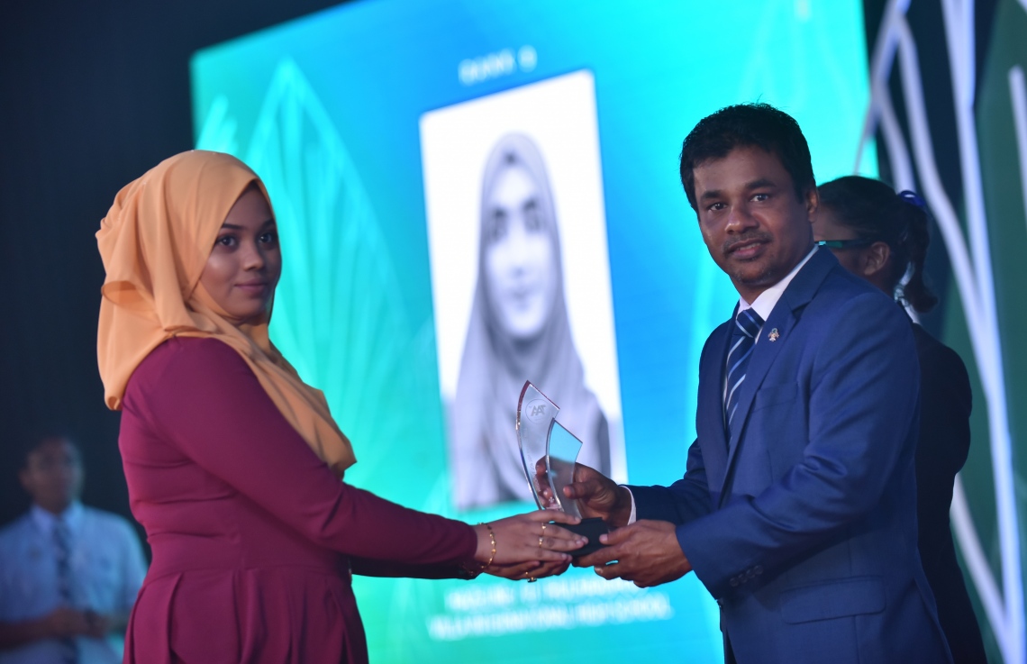 މާލެ: މާޗް 4، 2018- މިދިޔަ އަހަރުގެ އޭ ލެވެލް އިމްތިހާނުގެ ޓޮޕް އެޗީވާސް އެވޯޑް ދިނުމުގެ ރަސްމިއްޔާތުގައި، ހެލްތު މިނިސްޓަރު އަބްދުﷲ ނާޒިމް ދަރިވަރަކަށް އިނާމު ދެއްވަނީ---ފޮޓޯ: ހުސައިން ވަހީދު/މިހާރު