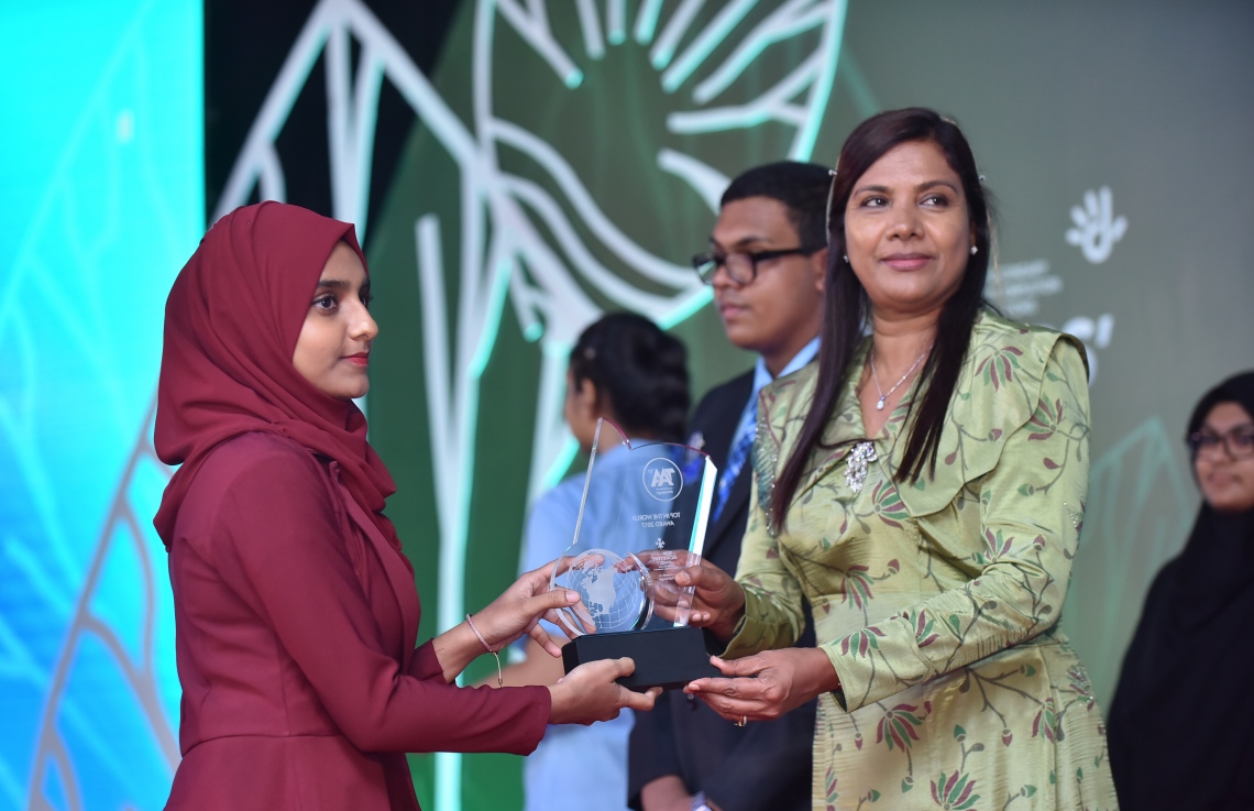 މާލެ: މާޗް 4، 2018- މިދިޔަ އަހަރުގެ އޭ ލެވެލް އިމްތިހާނުގެ ޓޮޕް އެޗީވާސް އެވޯޑް ދިނުމުގެ ރަސްމިއްޔާތުގައި އެޑިއުކޭޝަން މިނިސްޓަރު އައިޝަތު ޝިހާމް ދަރިވަރަކަށް އިނާމު ދެއްވަނީ---ފޮޓޯ: ހުސައިން ވަހީދު/މިހާރު